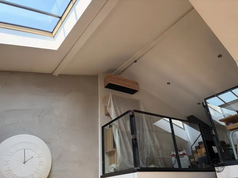 Unité intérieure posée sous les toits, à côté d'un Velux